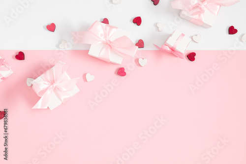 Valentine s Day background. Cute confetti hearts  gift box with bow on isolated pastel pink background. Valentine s Day concept. Flat lay  top view  copy space