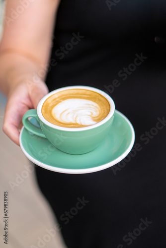 Girl holding a cup of cappuccino