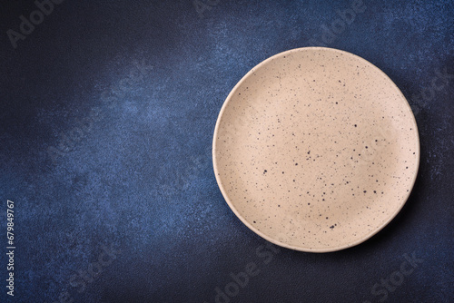 Round empty colored ceramic plate on concrete texture background