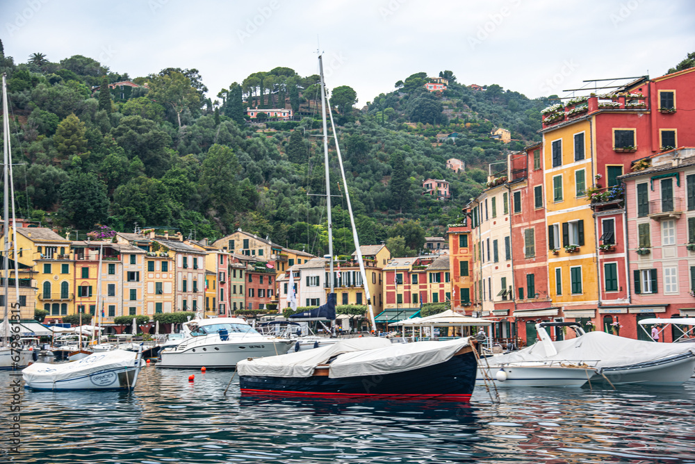 Panoramic view to the pier and colorful  apartments and Italian architecture of the see and the boat Portofino, Italy
