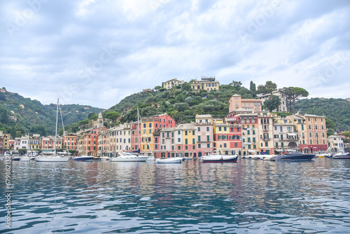 Panoramic view to the pier and colorful  apartments and Italian architecture of the see and the boat Portofino, Italy © Vanco