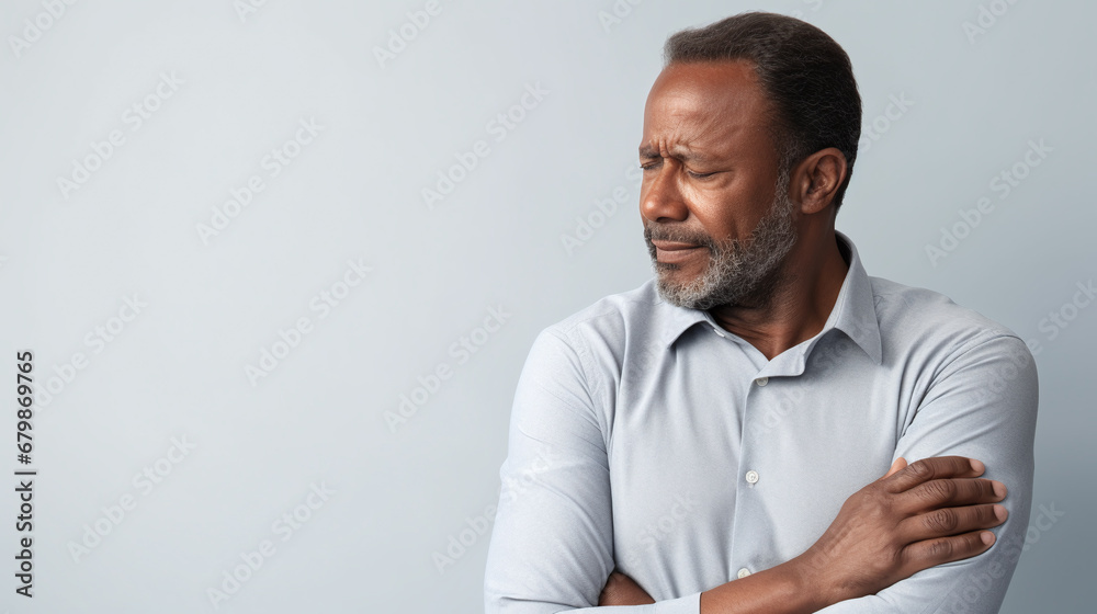 diseases and illnesses - man with face distorted in pain holds one hand at his neck,shoulder or upper arm diseases and illnesses - man with face distorted in pain holds one hand at his neck,shoulder or upper arm