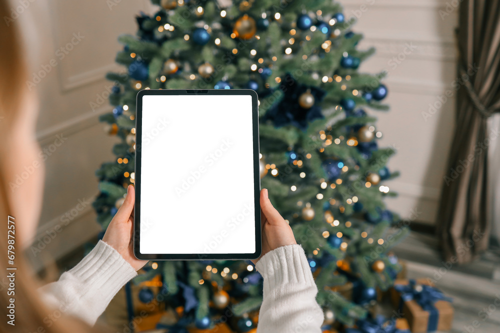 Girl working on a graphics tablet with isolated screen in a Christmas atmosphere Girl working on a graphics tablet with isolated screen in a Christmas atmosphere