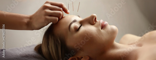 Woman undergoing acupuncture therapy procedure on facial skin in spa salon. Doctor hand with a needle near a girl face.