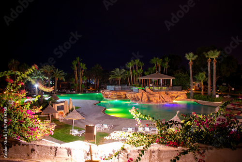 Swimming pool and palm trees at night in Hammamet, Tunisia