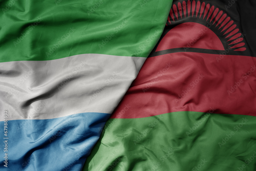 big waving national colorful flag of sierra leone and national flag of malawi .