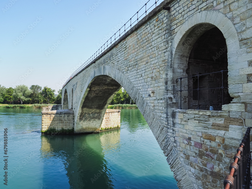 River Rhone and 12th-century bridge close up. Ruins of famous medieval Saint-Benezet bridge, also known as the Pont d'Avignon. Surviving four arches on one bank of the river. Avignon, Provence, France