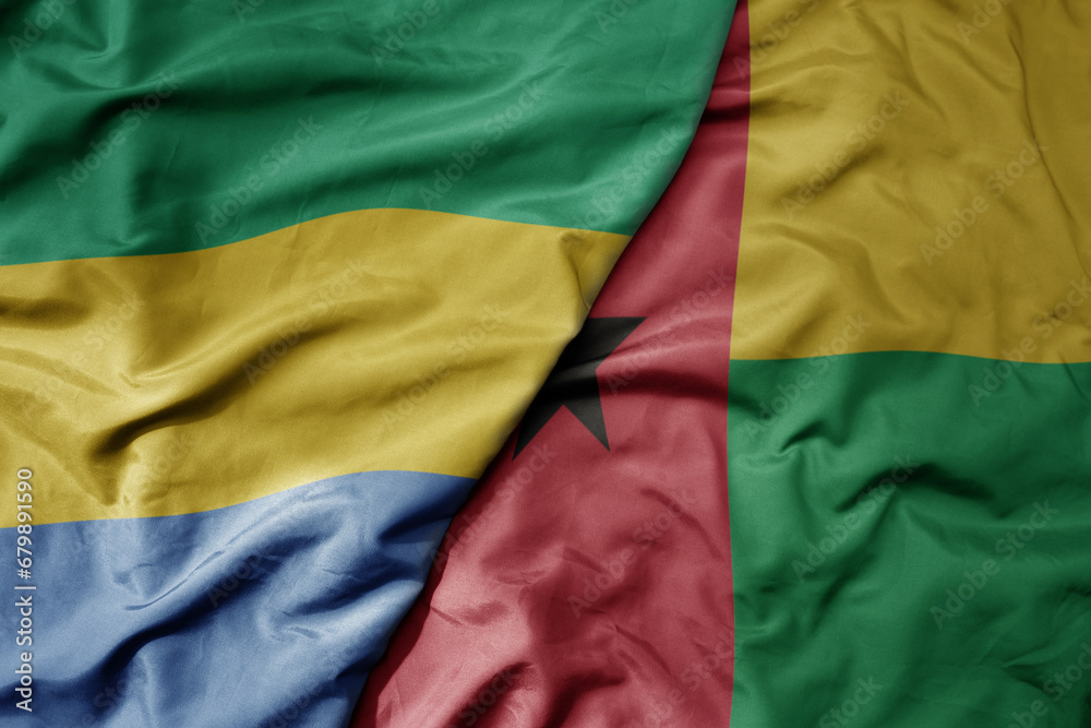 big waving national colorful flag of guinea bissau and national flag of gabon . big waving national colorful flag of guinea bissau and national flag of gabon .