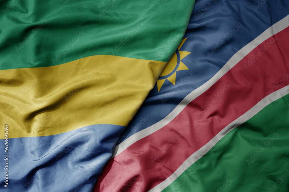 big waving national colorful flag of namibia and national flag of gabon .