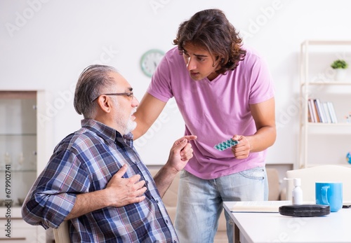 Young student and his old grandpa at home photo