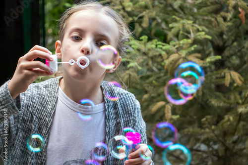 Little girl blowing soap bubbles. Child enjoying blowing soap bubbles