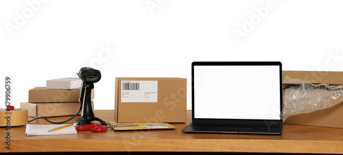 Parcels, laptop and barcode scanner on wooden table against white background. Online store photo