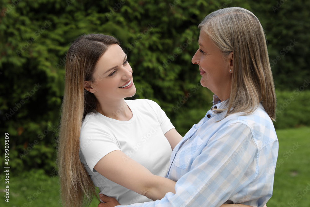 Happy mature mother and her daughter hugging in park Happy mature mother and her daughter hugging in park