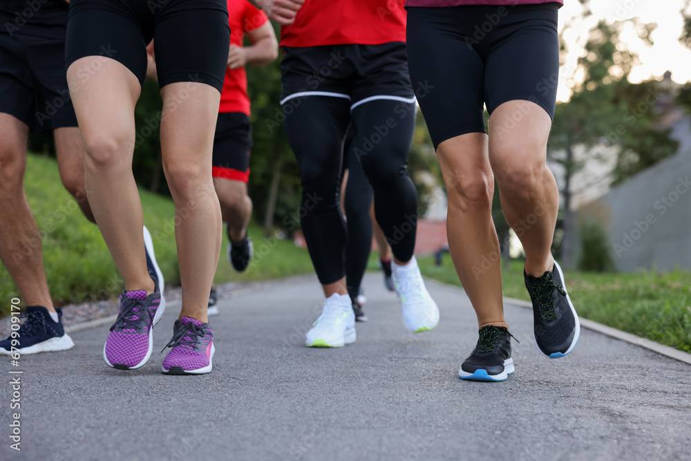Group of people running outdoors, closeup view Group of people running outdoors, closeup view