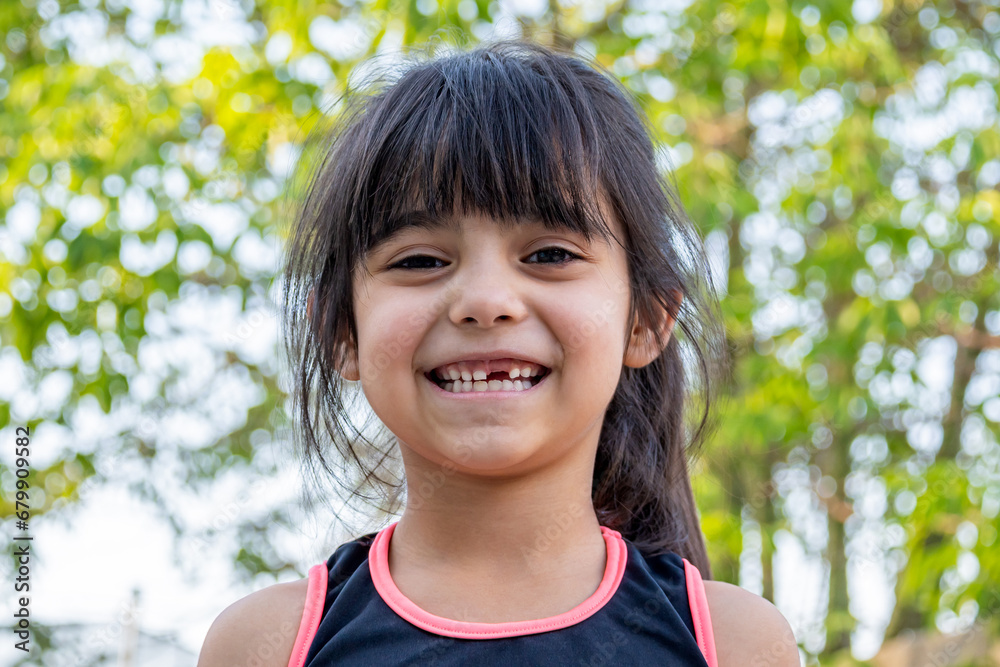 Close-up portrait of her. She is friendly, charming, sweet, curious and cheerful. Little girl outdoors in sports clothing. Close-up portrait of her. She is friendly, charming, sweet, curious and cheerful. Little girl outdoors in sports clothing.