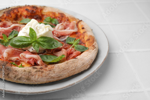 Delicious pizza with burrata cheese, basil and ham on white table, closeup. Space for text