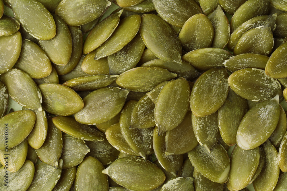 Many peeled pumpkin seeds as background, top view Many peeled pumpkin seeds as background, top view