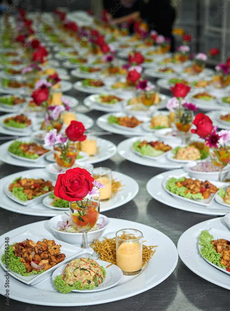 food being plated at a wedding. this image has a very shallow depth of field