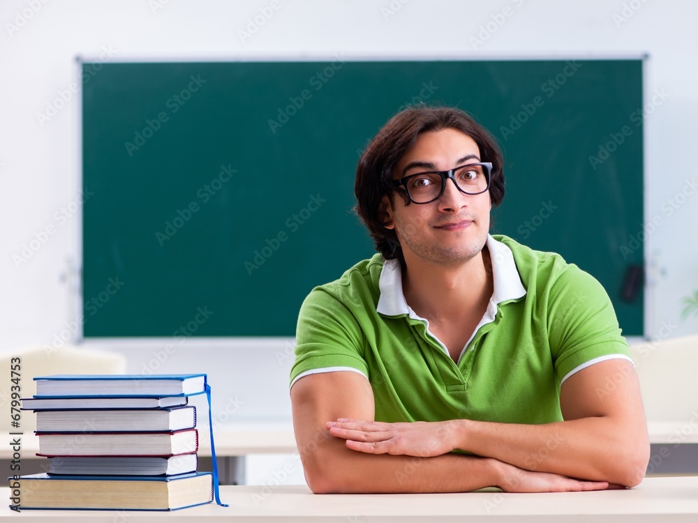 Young male student in front of green board Young male student in front of green board