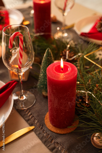 Burning candle on festive table at Christmas night, closeup
