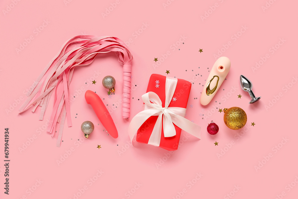 Composition with Christmas gift, sex toys and decorations on pink background