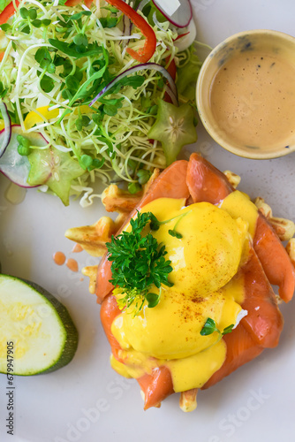 white plate with eggs bennedict waffles with smoked salmon on a white background photo