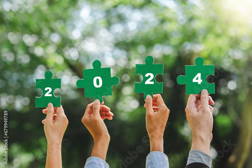 2024 World environment day and ESG Concept of teamwork and partnership Hands join Jigsaw puzzle pieces with number 2024 global community sustainable Save Earth.