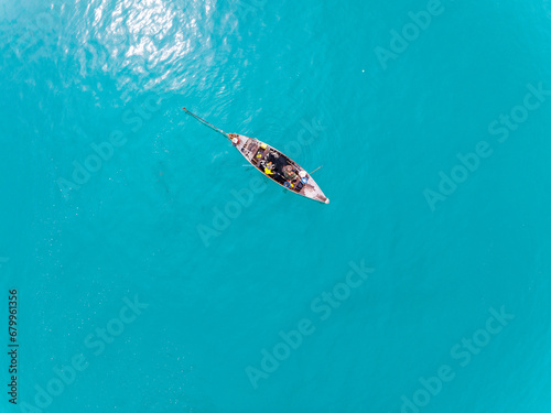 Top view Longtail fisherman boat in the tropical sea at Phuket island Thailand, Beautiful sea surface High angle view from drone camera