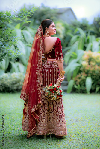 Asian woman in traditional costume,  Maroon embroidered velvet semi stitched lehenga photo