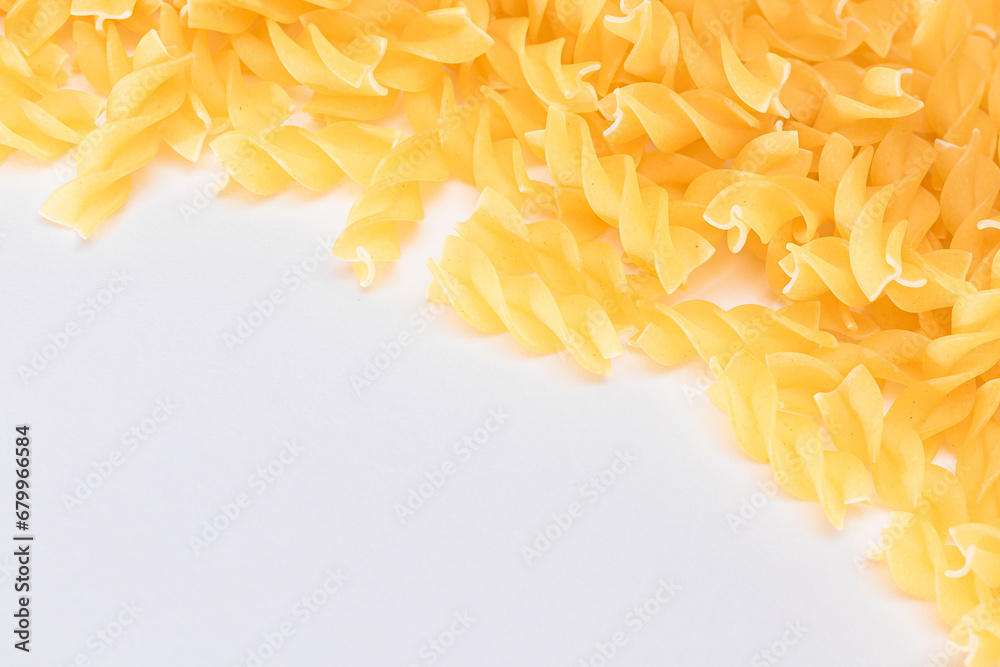 Fototapeta premium Uncooked Fusilli Pasta with Copy Space on White Background. Raw and Dry Macaroni. Fat and Unhealthy Food - Flat Lay