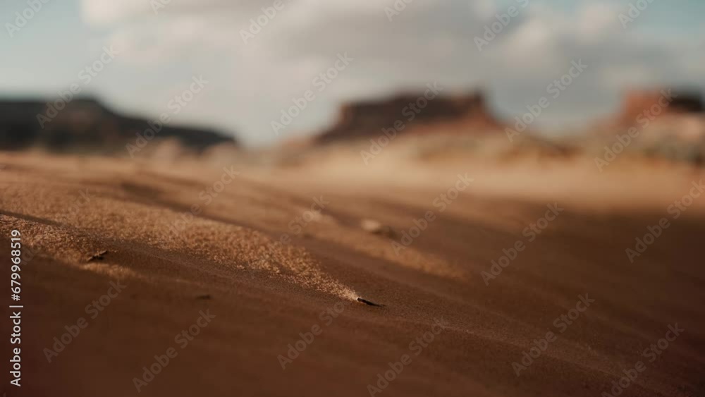 Grains of sand blowing in the desert wind during sunset