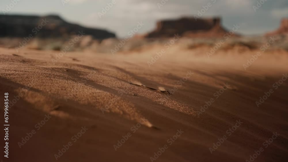 Grains of sand blowing in the desert wind during sunset