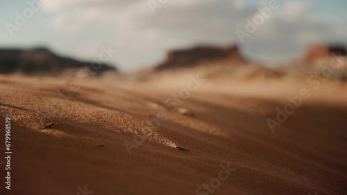 Grains of sand blowing in the desert wind during sunset
