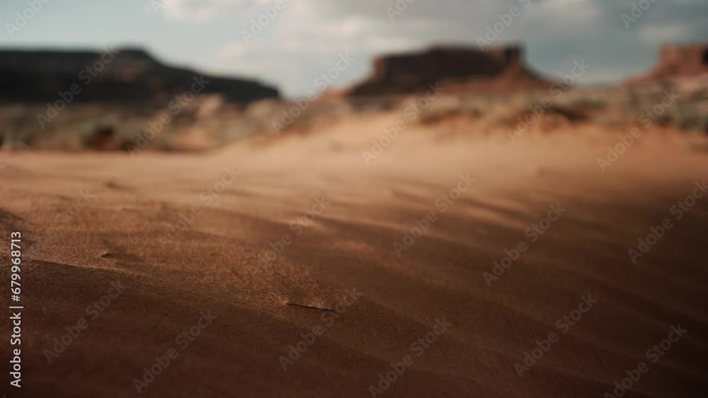 Grains of sand blowing in the desert wind during sunset