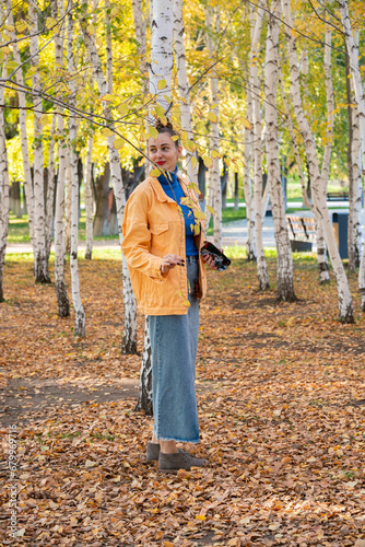 Young woman walking in the park in autumn.