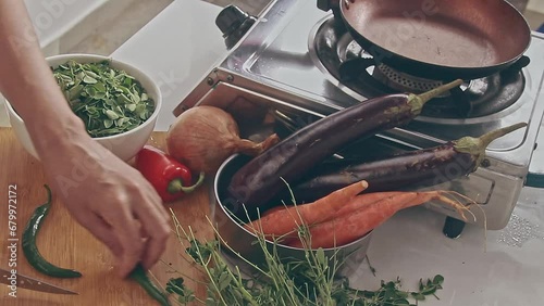 Slicing green chilies for cooking ginataan with moringa or malungay which is a soup cooked in coconut milk, a traditional Filipino dish showing the authentic cuisine and culture of the Philippines photo