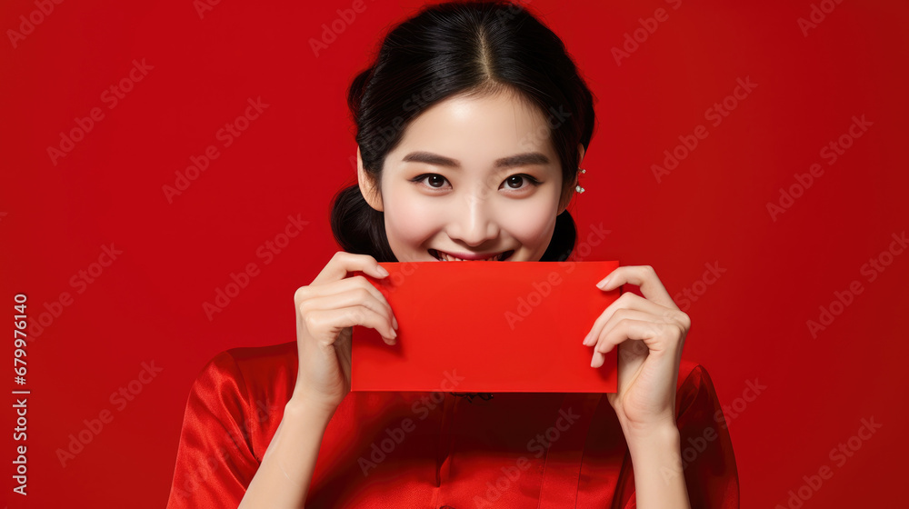 Fototapeta premium Fashion smiling girl wearing wearing Chinese traditional clothing, holding Hongbao, Chinese spring festival, Chinese new year