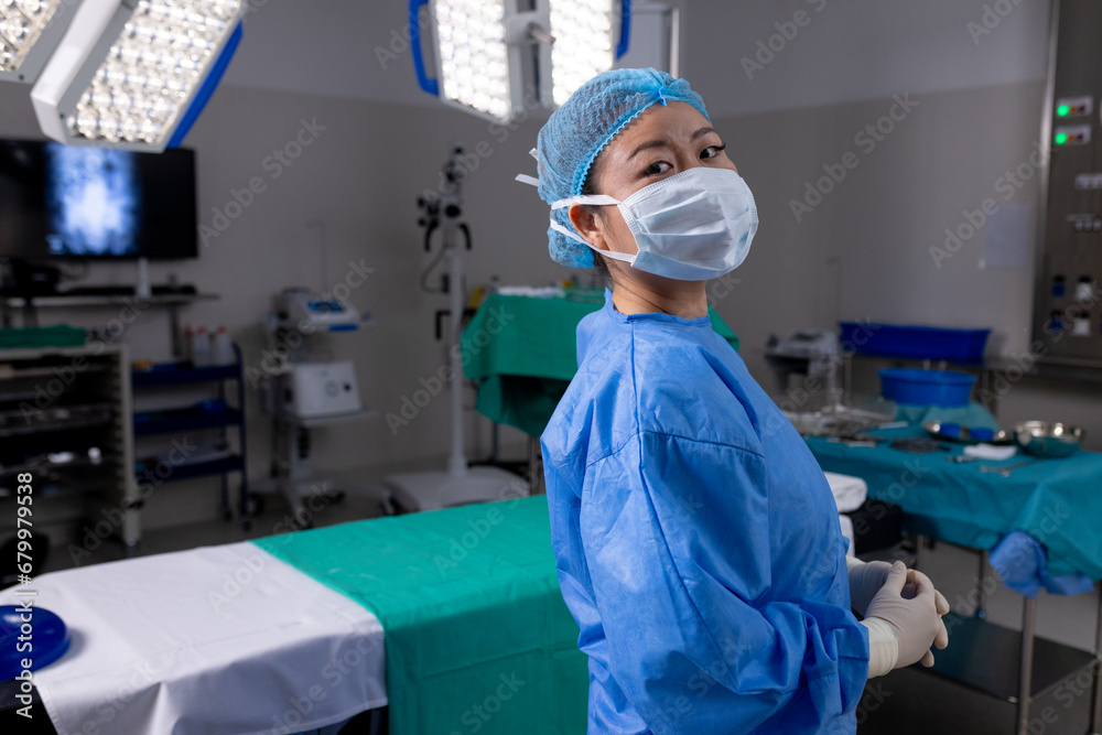 Portrait of asian female doctor with face mask and gloves in hospital operating room Portrait of asian female doctor with face mask and gloves in hospital operating room
