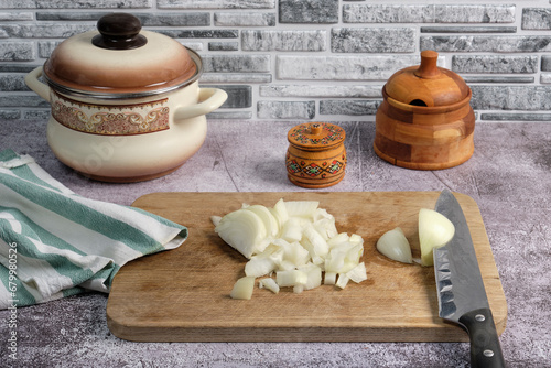 Obraz na płótnie onion chopped into large cubes using a knife on a wooden cutting board