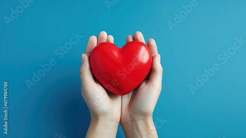 Young women hands holding red heart  health care  donate and family insurance concept  world heart day  world health day. isolated on blue background