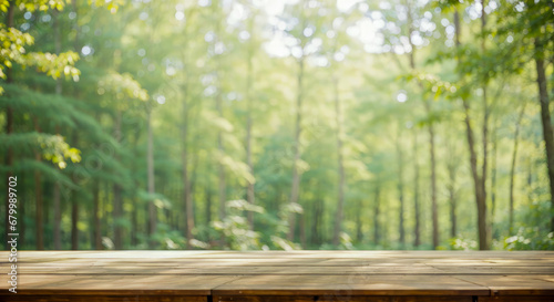 Product placement In green forest. empty wooden table against blurred green forest background. wooden table stands  surrounded by tall trees blurred background