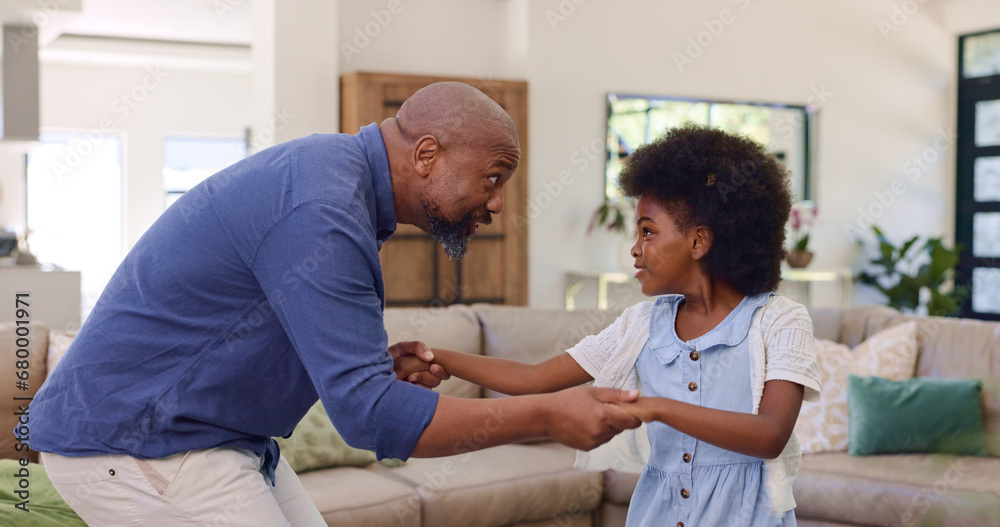 Fototapeta premium Father, daughter and dancing in living room for holding hands, relax and bonding with music and movement. Black family, man or girl child with having fun, dancer and teaching steps in lounge of house