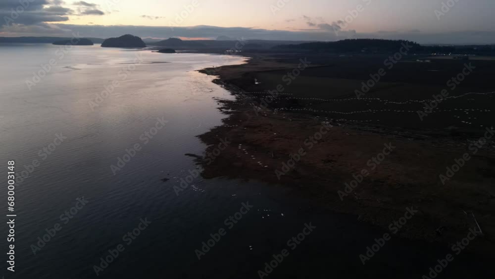 Dusk Over Coastal Estuary with Bird Formations and Tidal Flats Dusk Over Coastal Estuary with Bird Formations and Tidal Flats