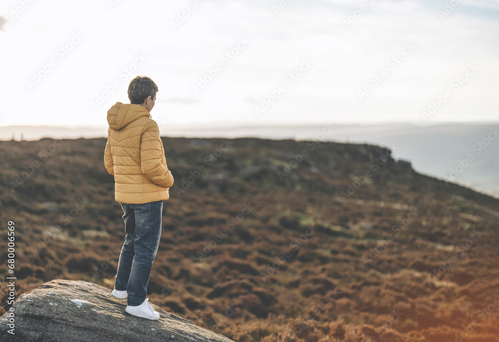 woman hiking in mountain to take timelaps of sunrise, exercise and fitness for wellness, healthy lifestyle and smile. senior mature gentleman sitting on rock, enjoing calm day toned image