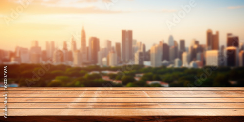 Wooden table top with blurred city skyline at sunset.