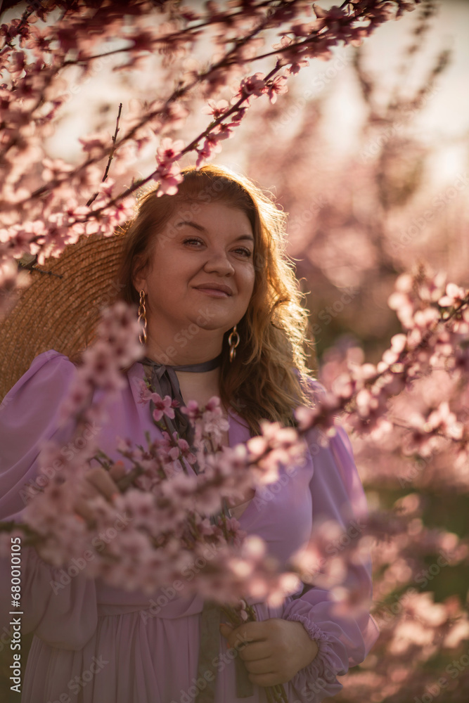 Woman blooming peach orchard. Against the backdrop of a picturesque peach orchard, a woman in a long pink dress and hat enjoys a peaceful walk in the park, surrounded by the beauty of nature. Woman blooming peach orchard. Against the backdrop of a picturesque peach orchard, a woman in a long pink dress and hat enjoys a peaceful walk in the park, surrounded by the beauty of nature.