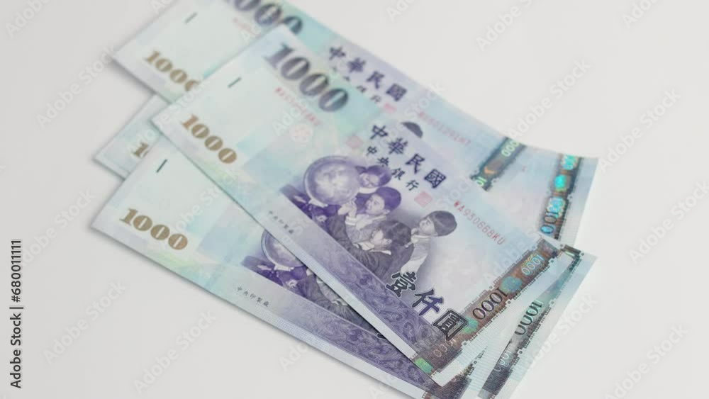 Hands counting a stack of thousand dollar Taiwan banknotes.New Taiwan Dollar Hands counting a stack of thousand dollar Taiwan banknotes.New Taiwan Dollar