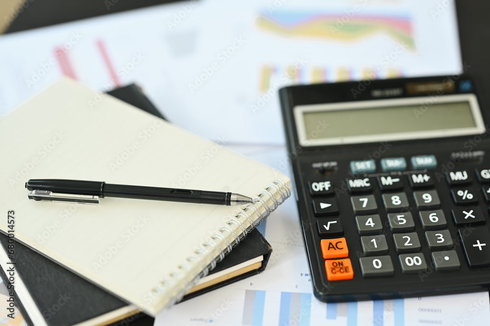 Calculator machine, notepad and financial documents on office table Calculator machine, notepad and financial documents on office table