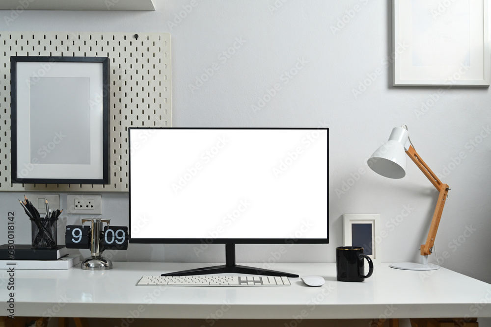 Fototapeta premium Front view blank computer monitor, lamp, clock, books and coffee cup on white table