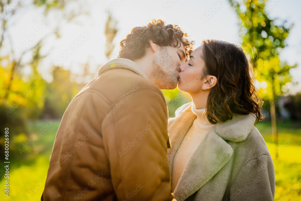 Happy loving couple kissing in park in sunset. Happy loving couple kissing in park in sunset.